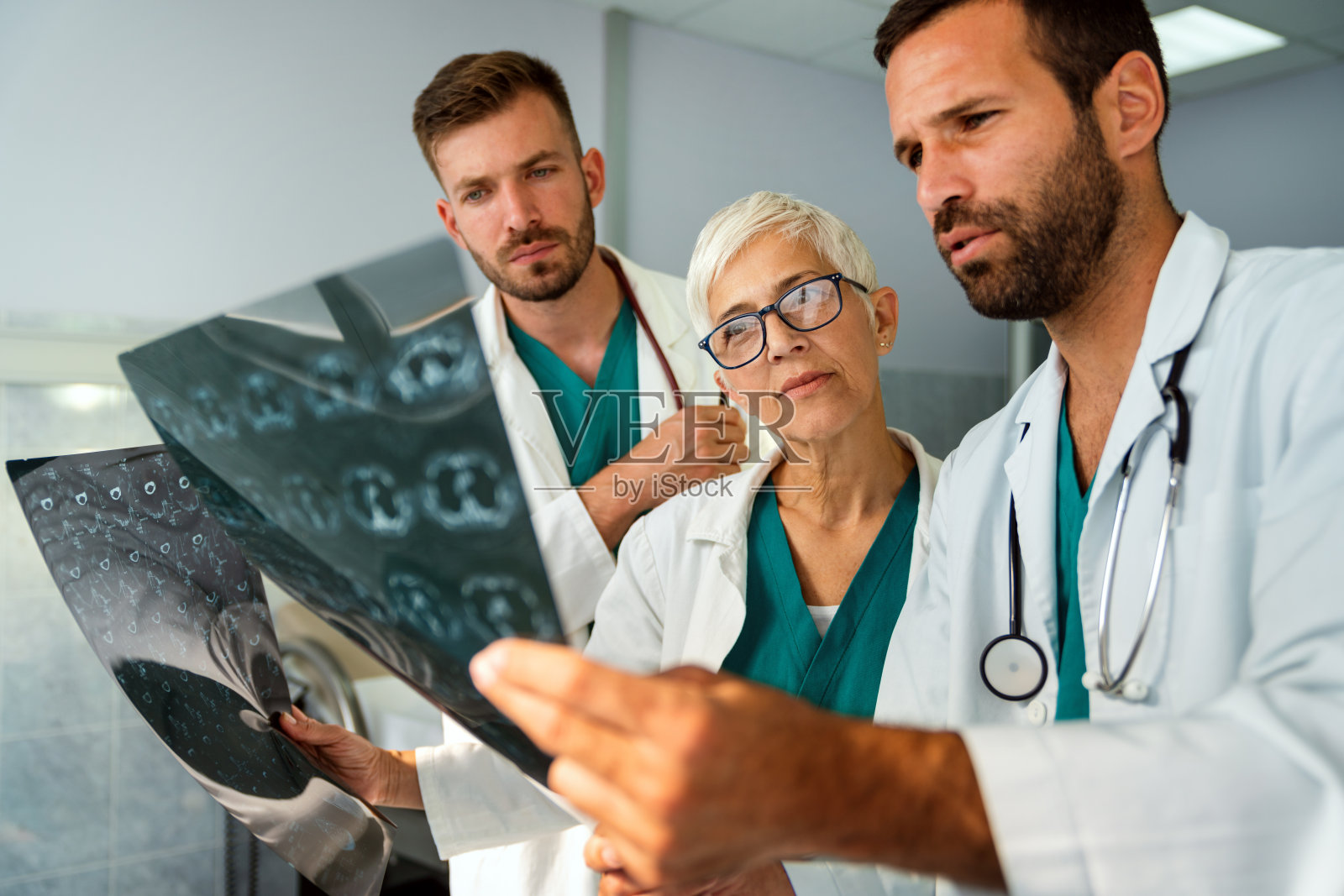 放射科医生小组正在看x光片并讨论它。照片摄影图片