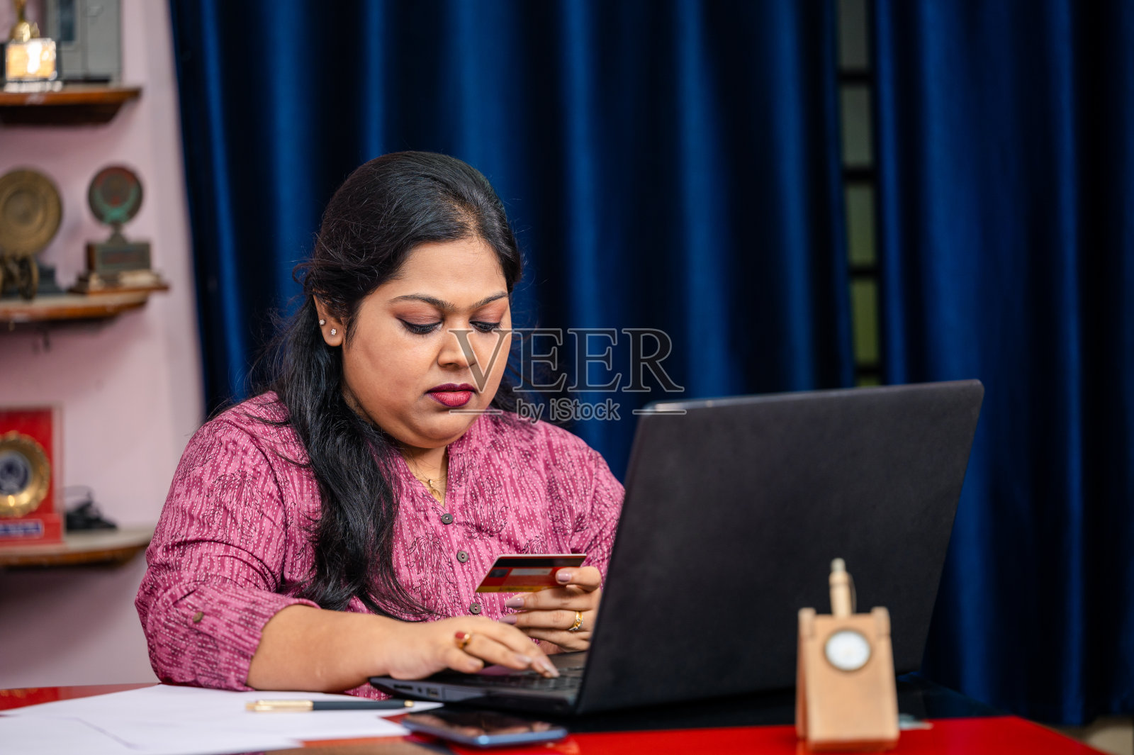 年轻女子在网上购物，用信用卡付款。照片摄影图片