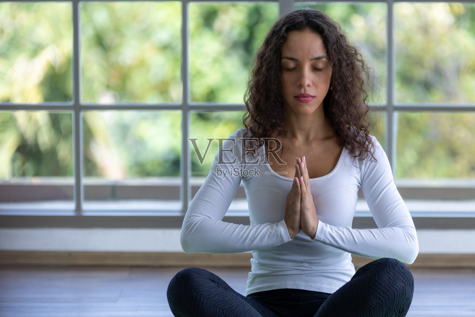 年轻女子练习瑜伽，莲花坐，锻炼，莲花姿势，合十，在家锻炼照片摄影图片