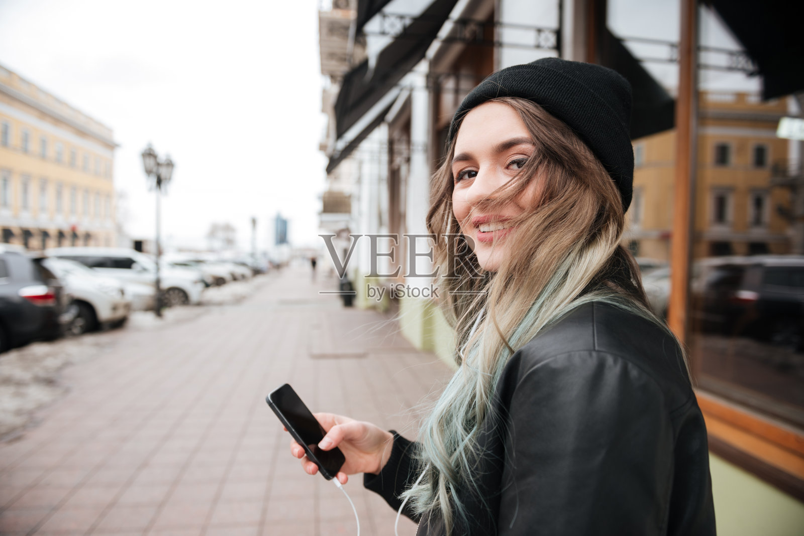 微笑的年轻女子听着音乐，聊天。照片摄影图片