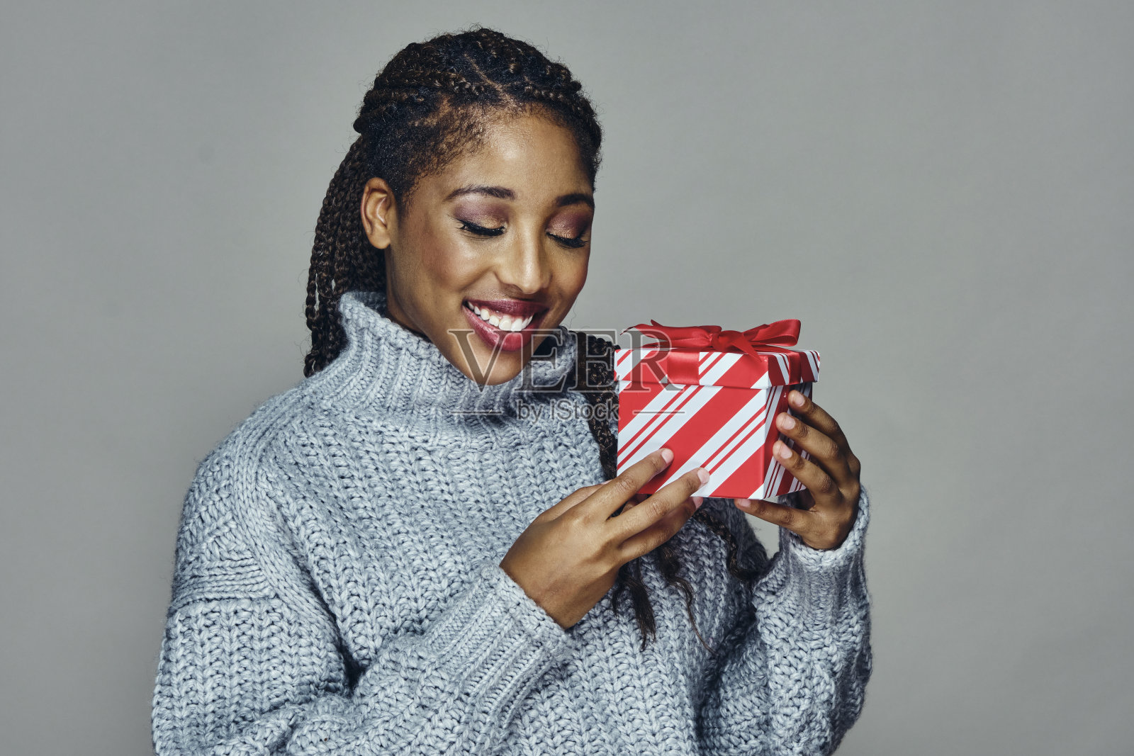 迷人的微笑的年轻女子手持圣诞礼物照片摄影图片