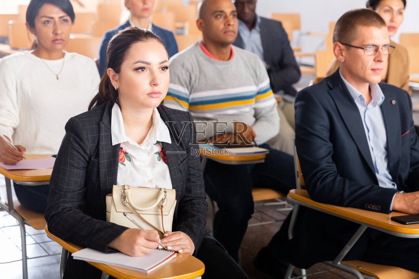 一名年轻女子在商业会议上听演讲照片摄影图片
