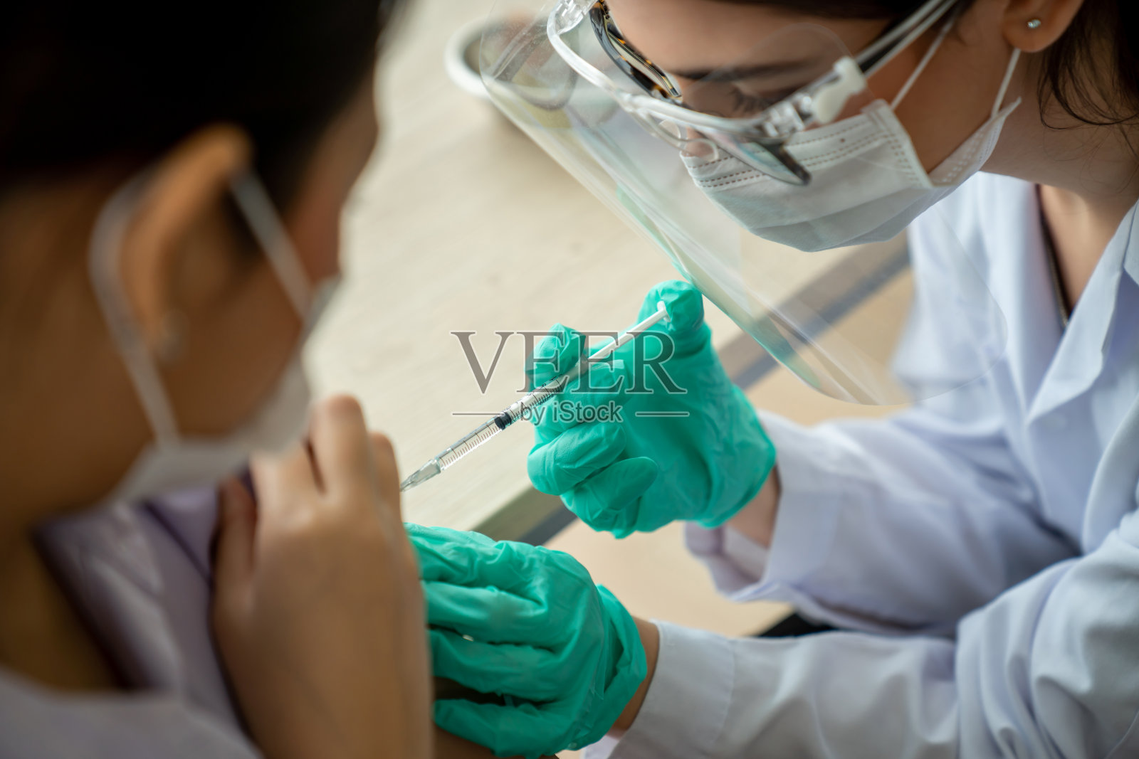 年轻女子到医院找技术熟练的医生接种疫苗照片摄影图片