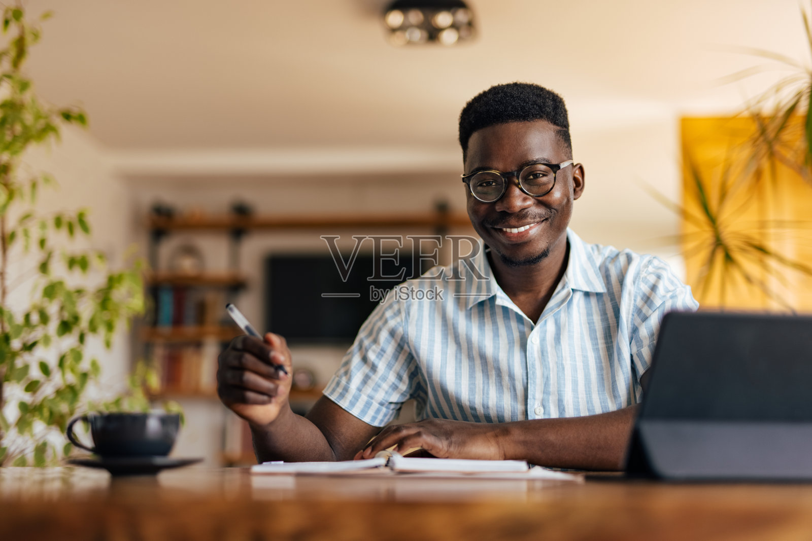 一个成年人，在他的新笔记本上快乐地写着。照片摄影图片