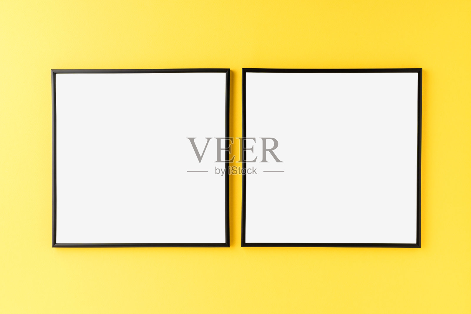 两个黑色相框，黄色背景上有空白。家居装饰照片摄影图片