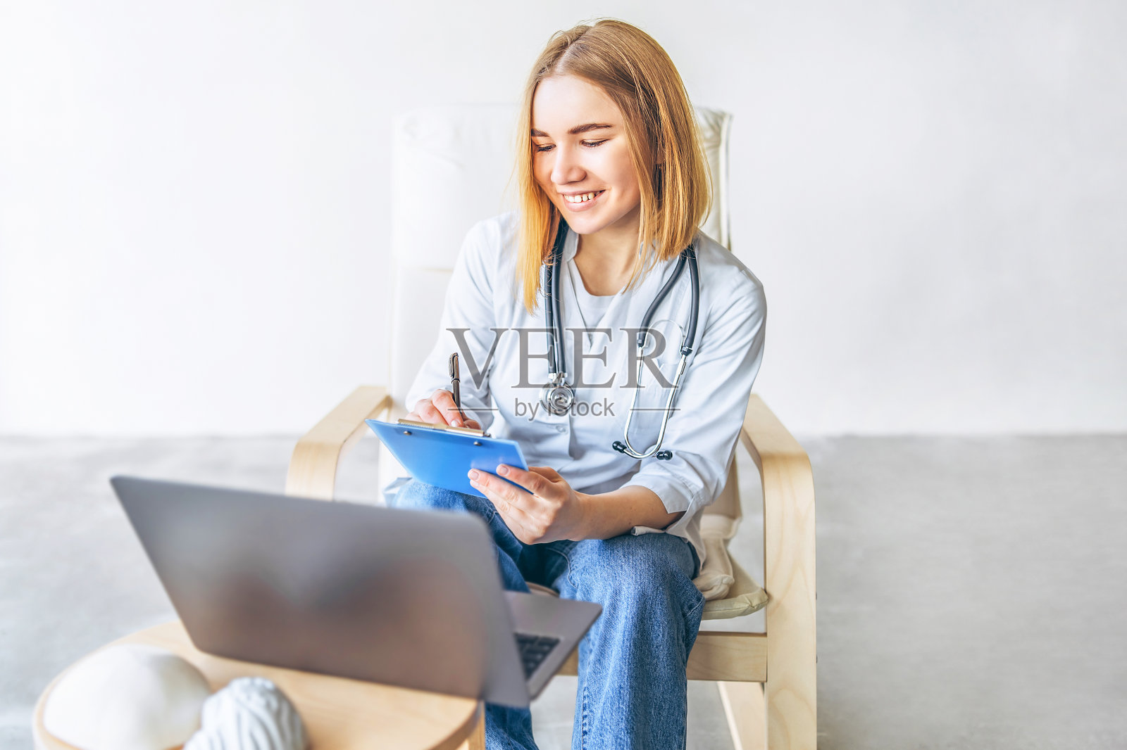 女医生坐在医院的办公桌上给病人提供在线服务建议。照片摄影图片