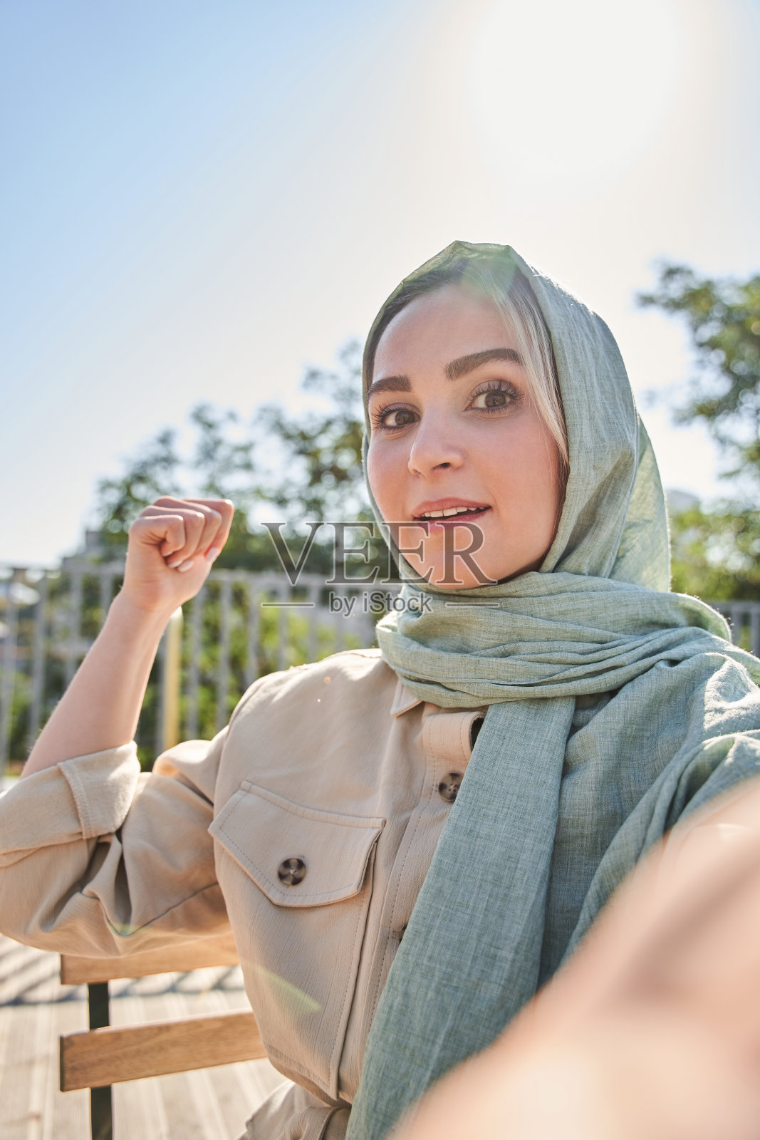 戴头巾的女子在城市环境中录制博客照片摄影图片