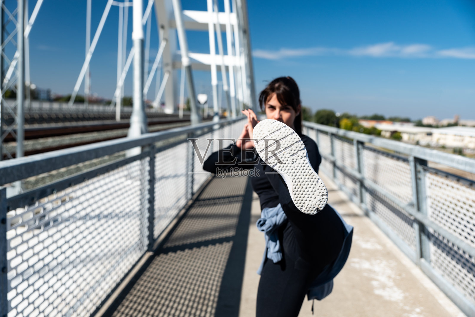 肌肉发达的女拳击手在运动服使前腿踢。跆拳道女运动员把踢腿训练作为力量和调节自我防卫的户外锻炼。照片摄影图片