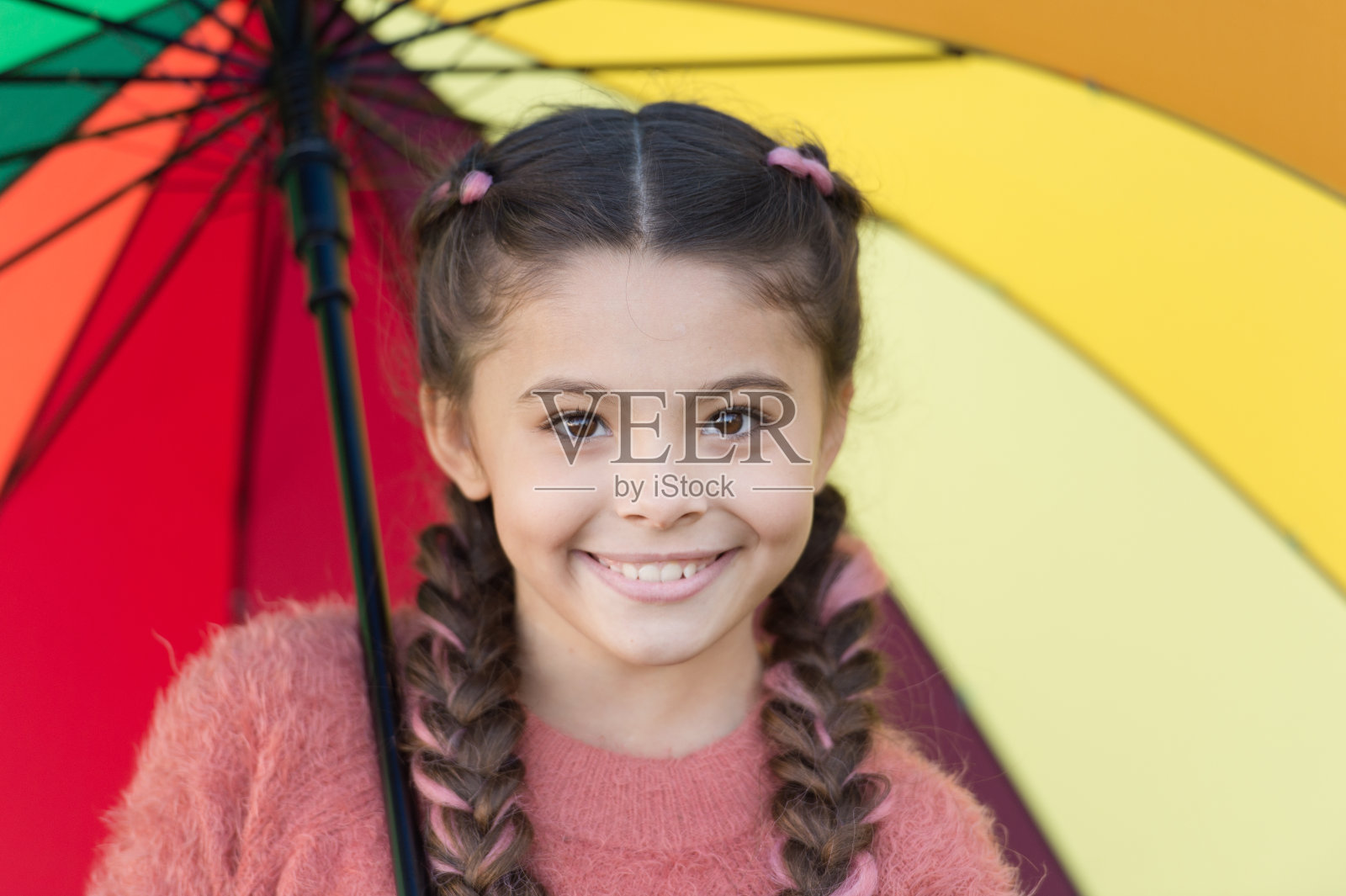 丰富多彩的配件，愉悦心情。女孩长发打着伞走路。保持积极乐观。丰富多彩的配件积极影响。明亮的伞。让微笑成为你的伞照片摄影图片