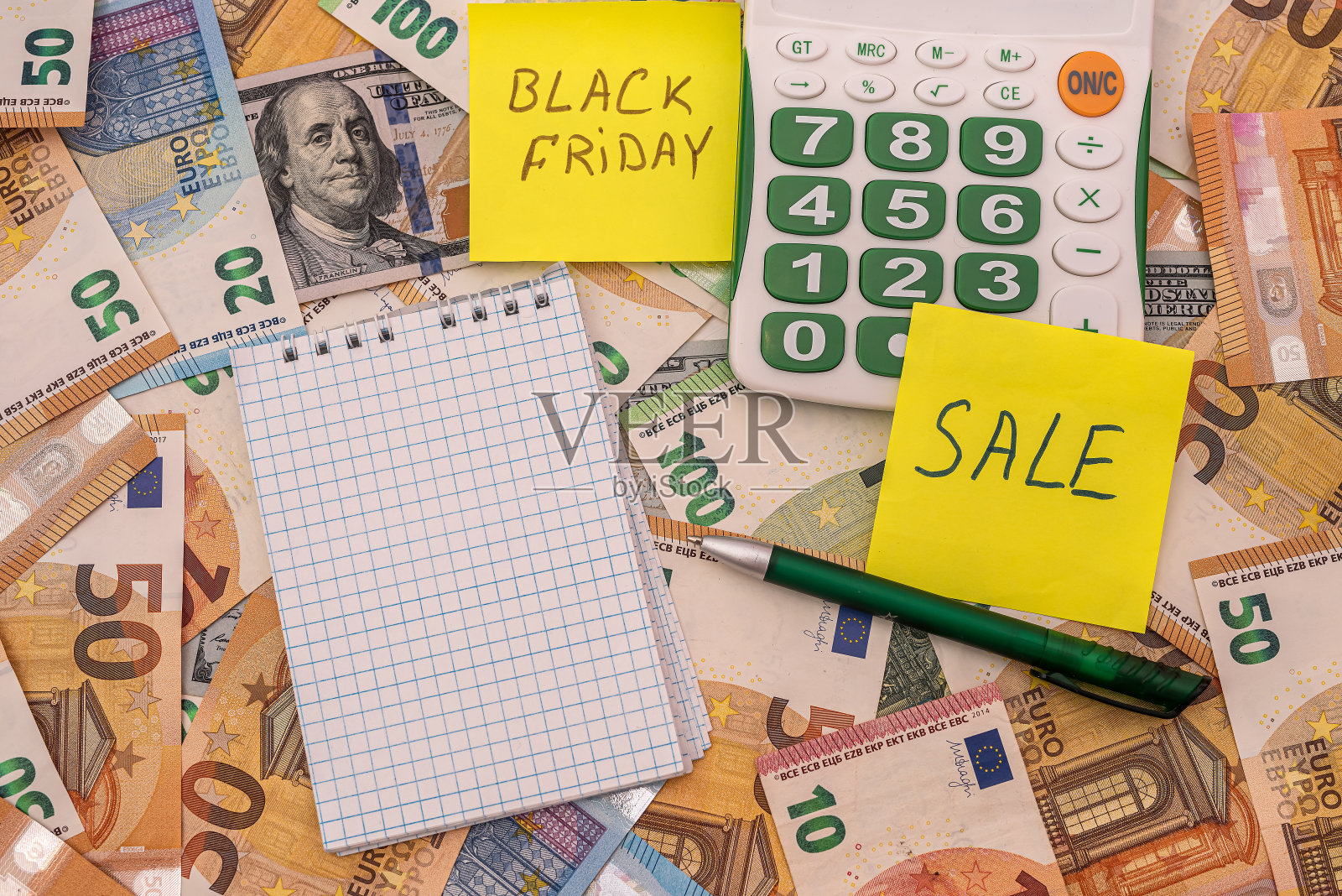 黑色星期五写在购物的备忘录、美元和欧元上。照片摄影图片