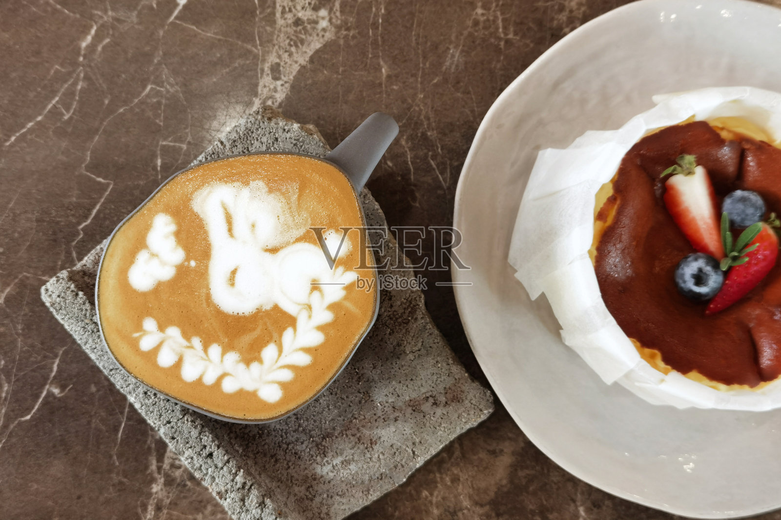 一杯拿铁咖啡和桌上的蛋糕照片摄影图片