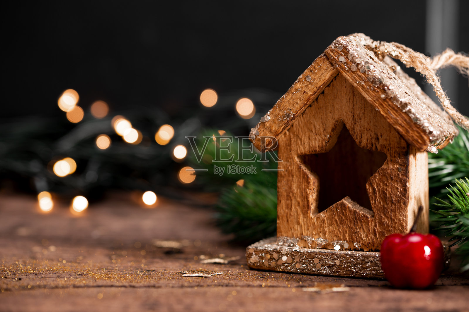 新年贺卡与自由空间的文字。木制的房子和圣诞装饰在黑暗的背景与美丽的散景照片摄影图片