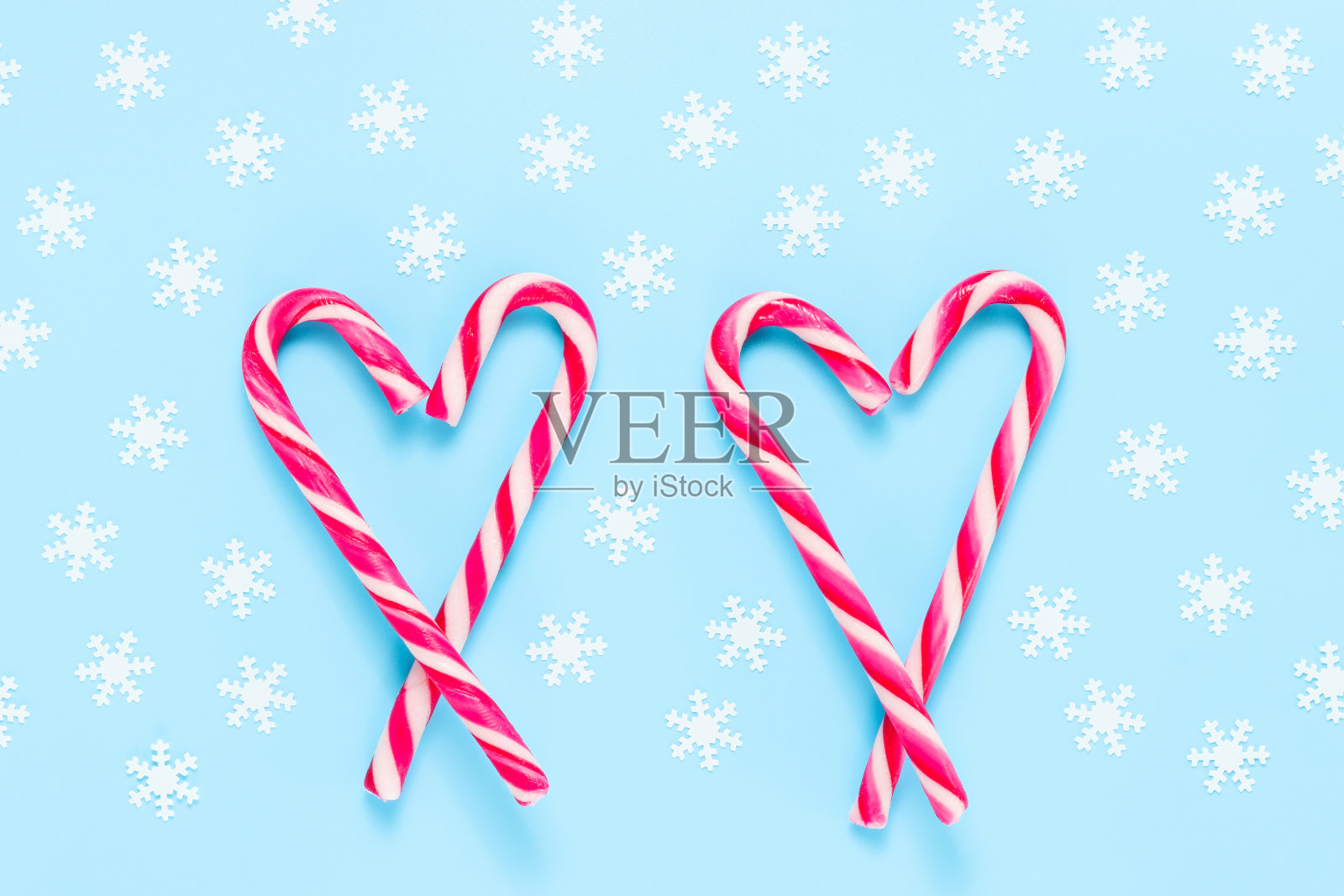 在蓝色背景上有雪花的心形圣诞拐杖糖照片摄影图片