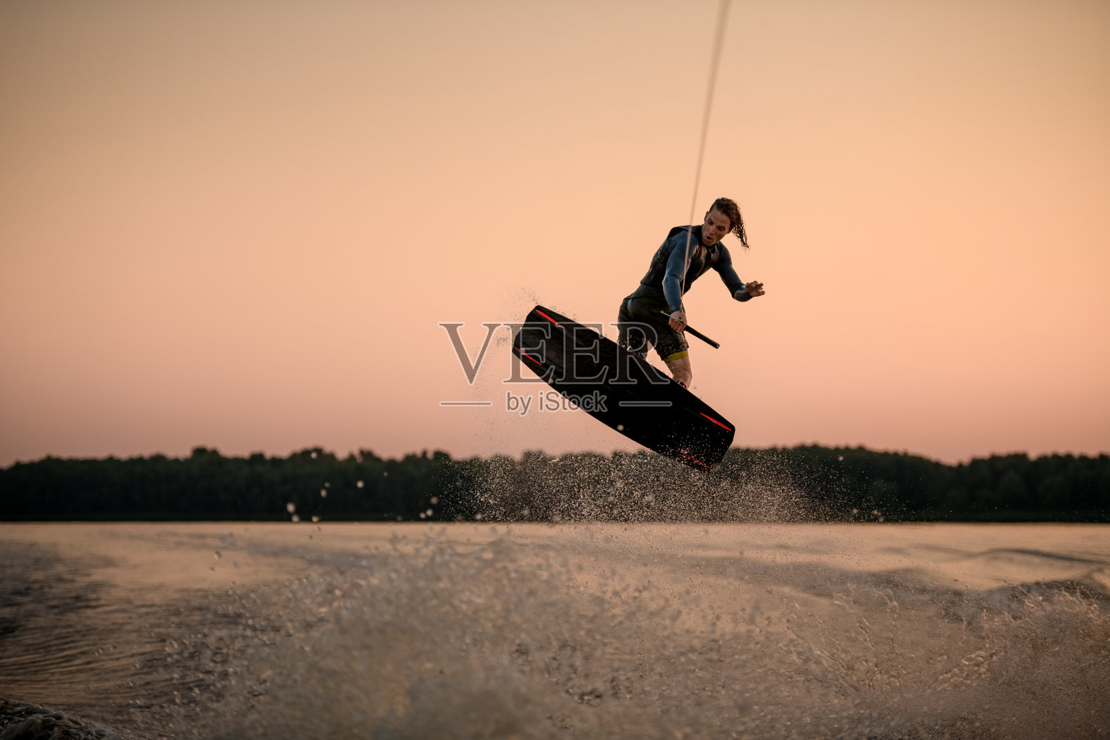 男子水上滑水者在水上滑水空中跳跃时的精彩画面照片摄影图片