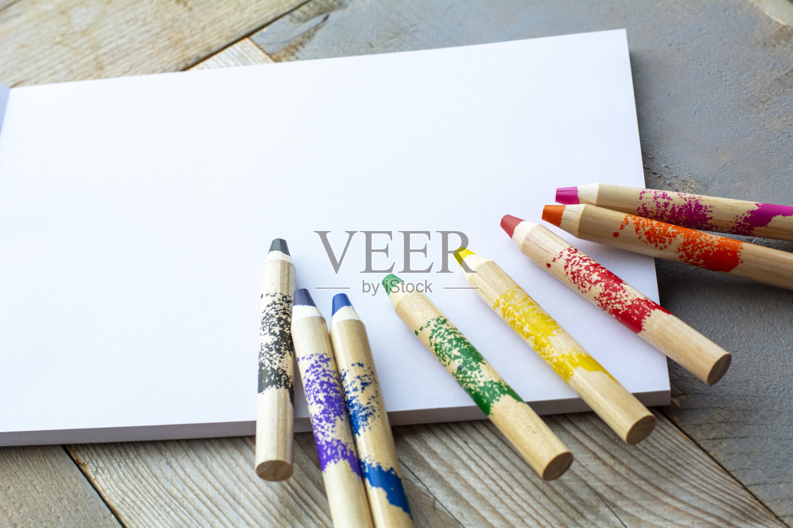 彩色铅笔放在笔记本上。孩子们的铅笔照片摄影图片