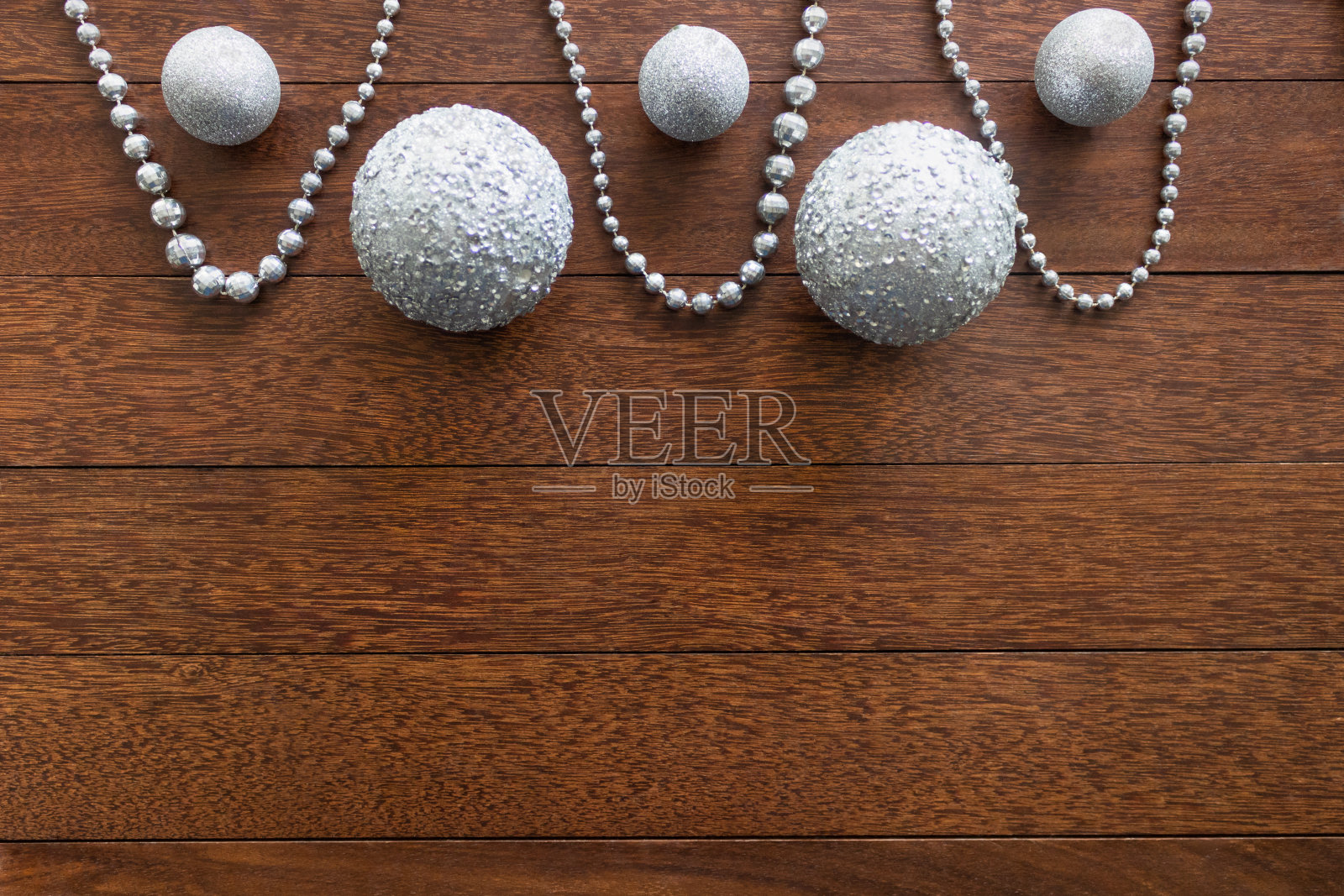 木制背景上有银链和球的圣诞作文照片摄影图片