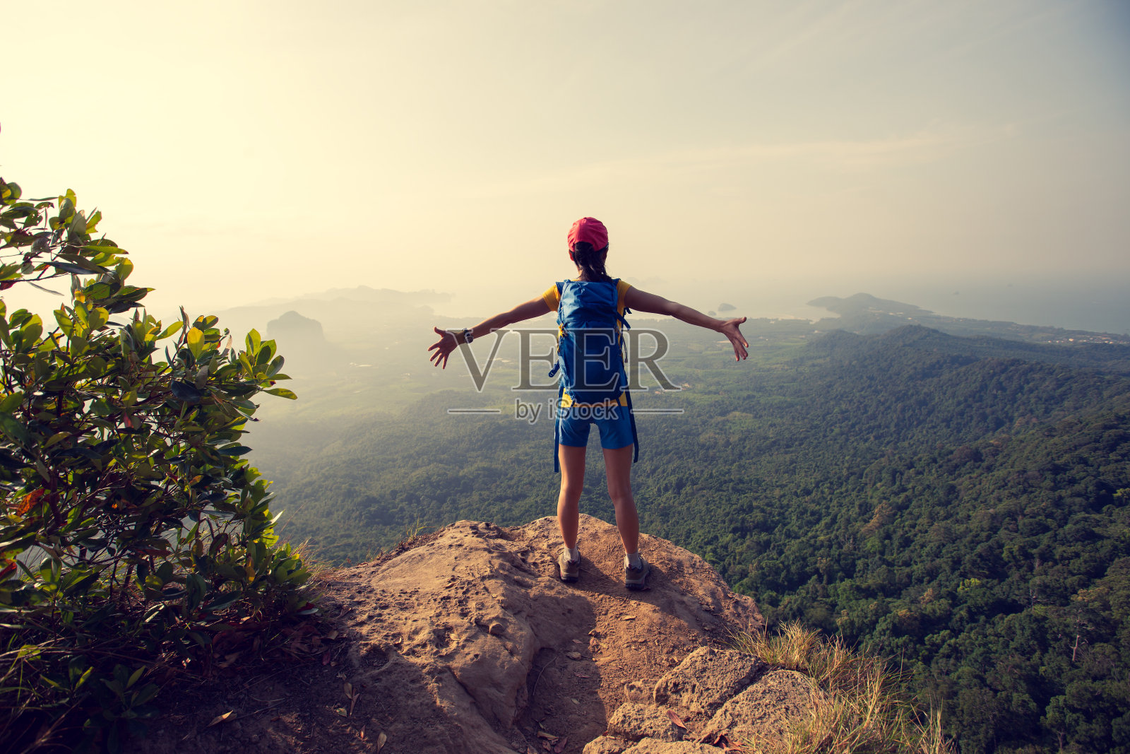 成功的女性徒步者在山顶的悬崖边欣赏风景照片摄影图片