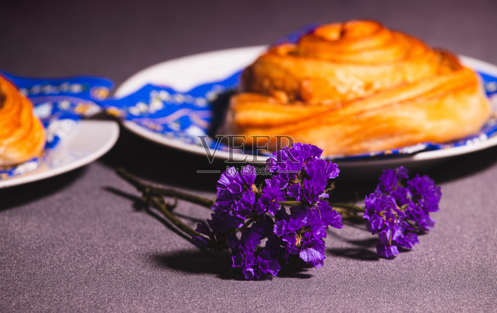 蓝色的花朵和模糊的羊角面包。早餐桌上。照片摄影图片