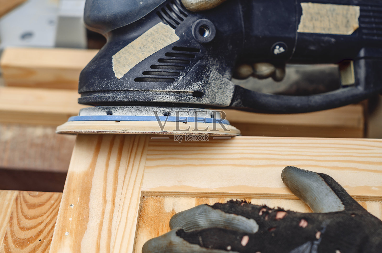 用手持电动砂光机打磨木板照片摄影图片
