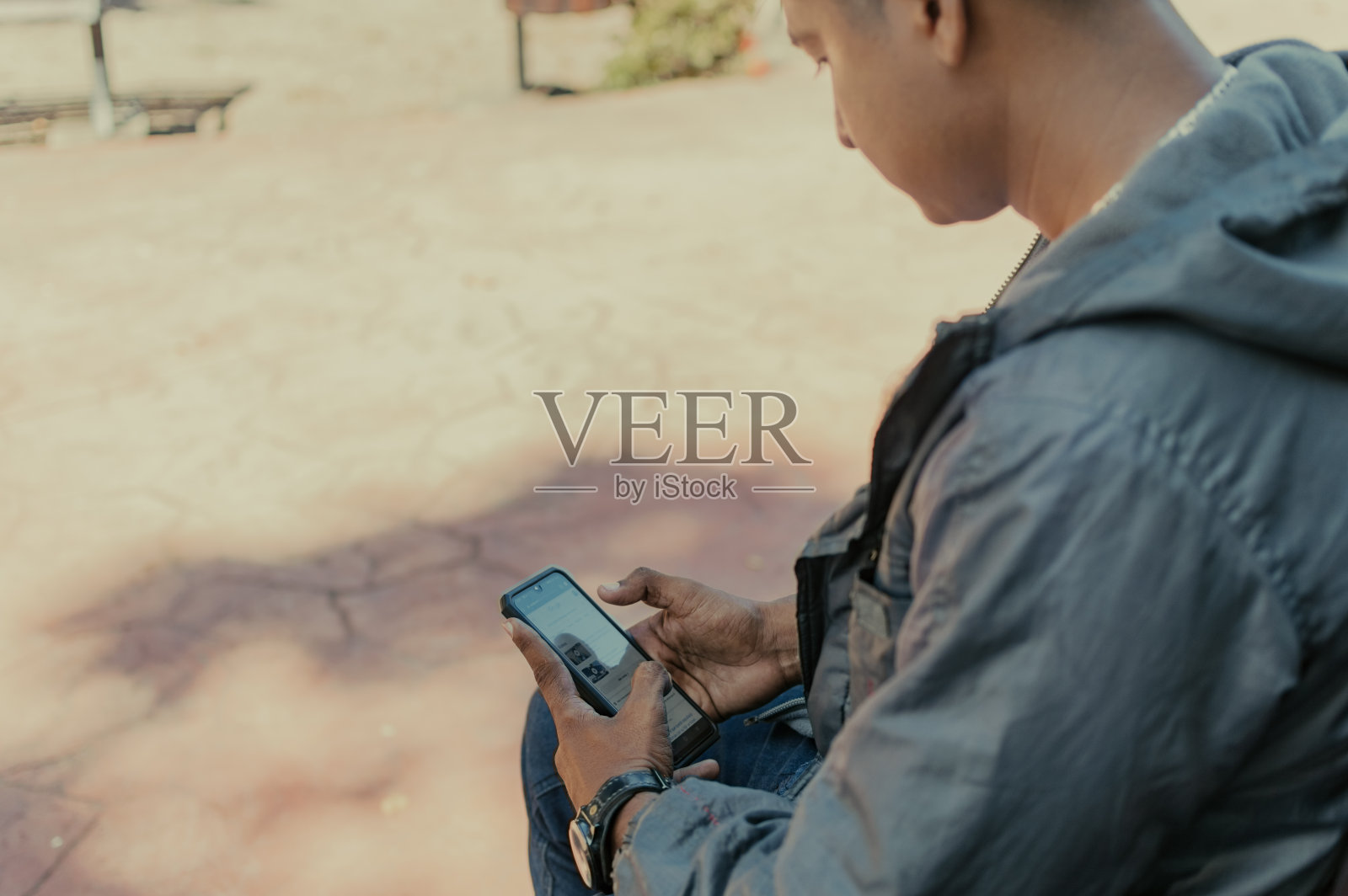 一个男人拿着手机的特写，一个人检查他的手机的特写，一个年轻人拿着手机的拷贝空间照片摄影图片