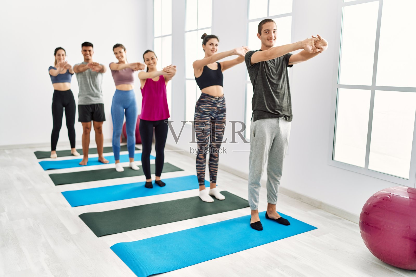 一群年轻的西班牙人在运动中心微笑快乐地伸展身体。照片摄影图片