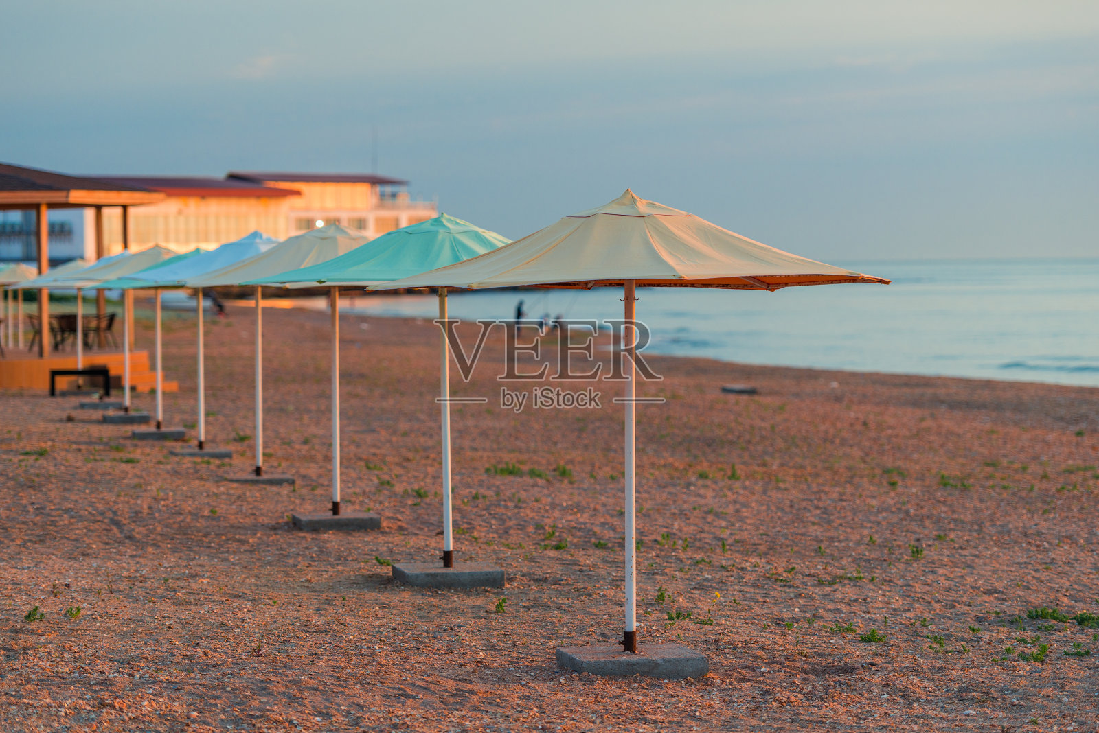 早晨海边沙滩上的一排沙滩伞照片摄影图片