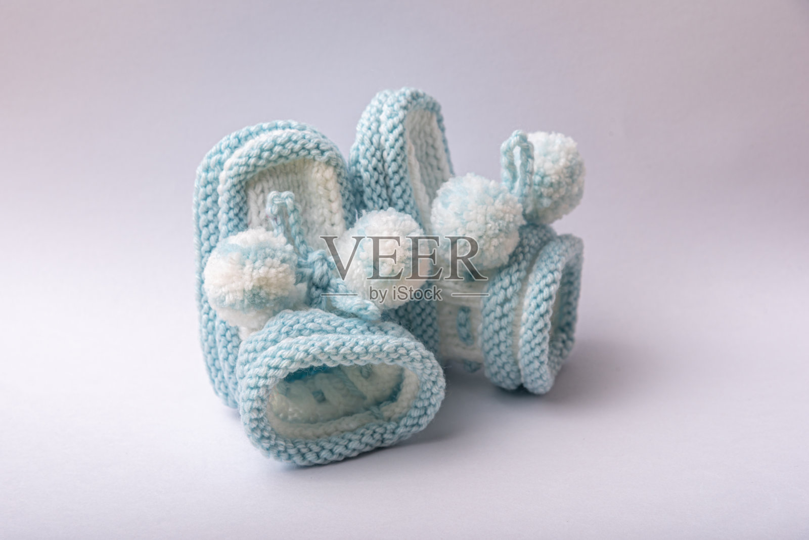 白色背景下为新生男孩自制的针织鞋照片摄影图片