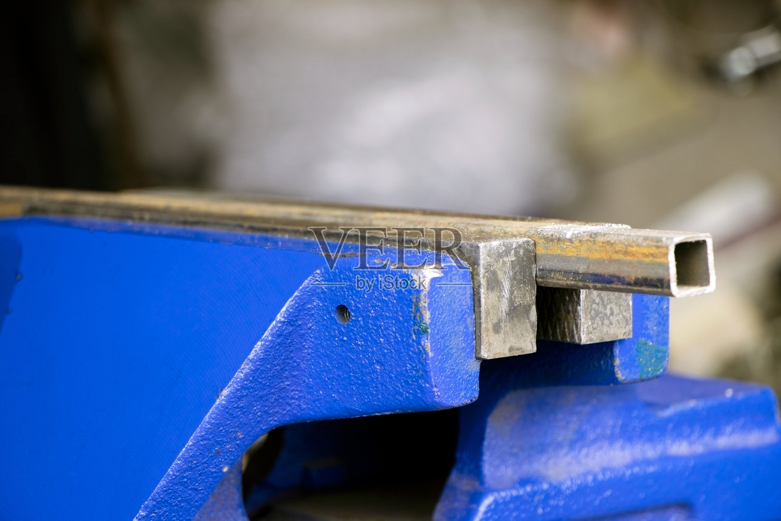 蓝色的虎钳放在木桌上。台式工具。副。男人们的手握着虎钳。固定金属型材照片摄影图片