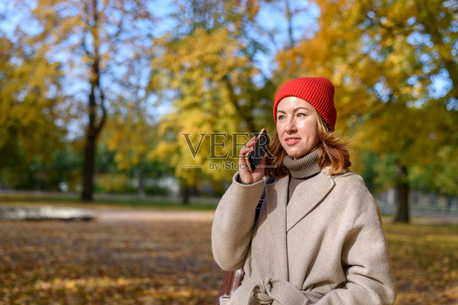 一个女人在秋天公园打电话照片摄影图片