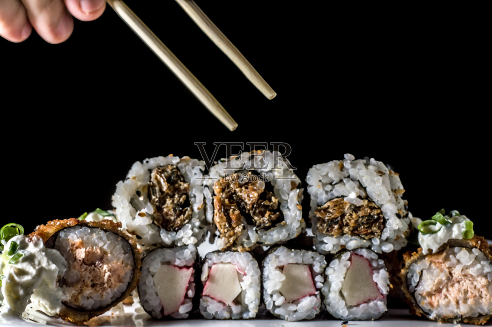 寿司，白色盘子和黑色背景的几种寿司照片摄影图片