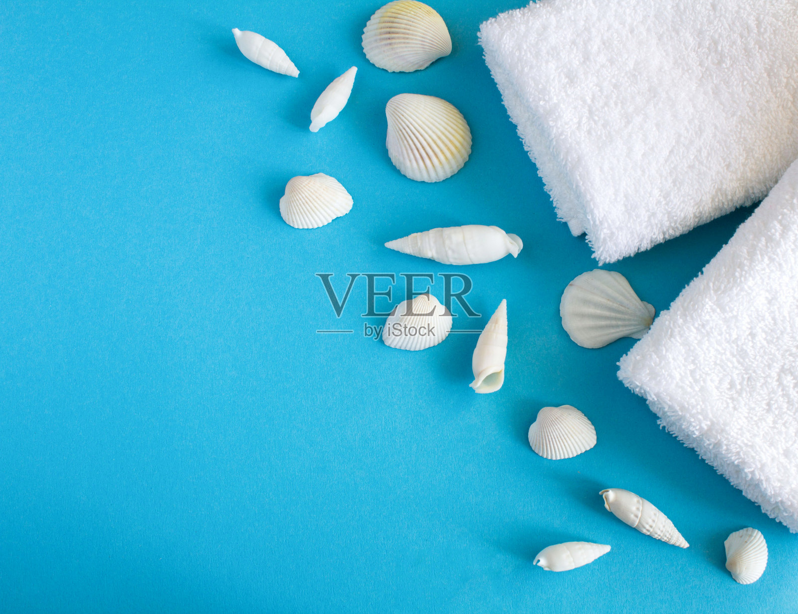 蓝色背景上有白色毛巾和贝壳。前视图。副本的空间。照片摄影图片