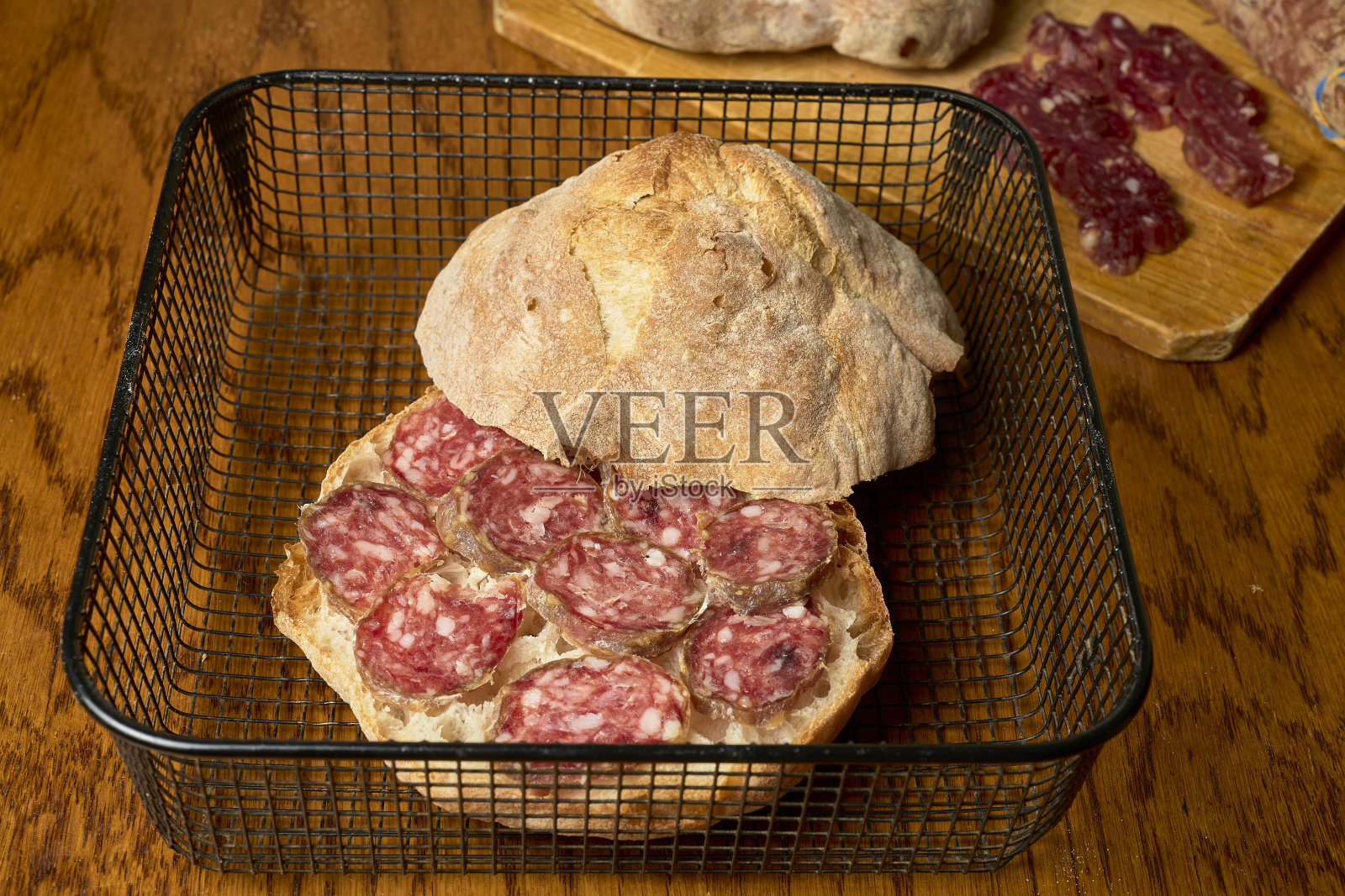 金属篮子里的意大利辣香肠三明治。照片摄影图片