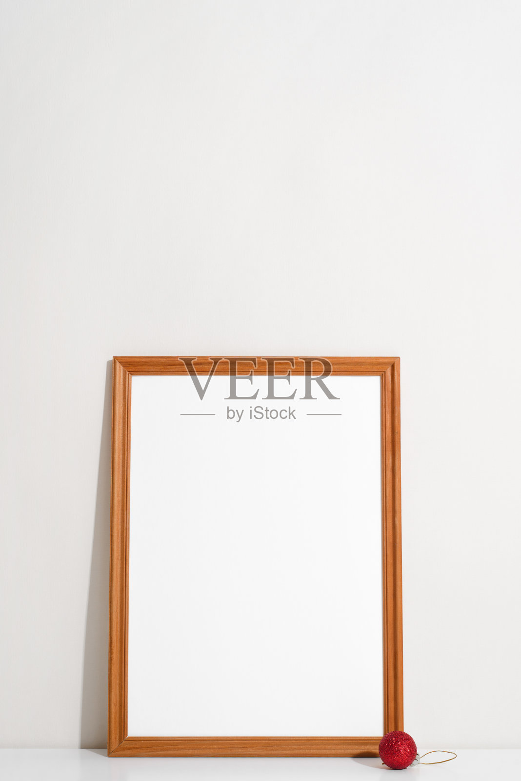 垂直人像框架模型与空白空间。圣诞红球，木框白色空白图片模板在室内的桌子上。节日最少的装饰照片摄影图片