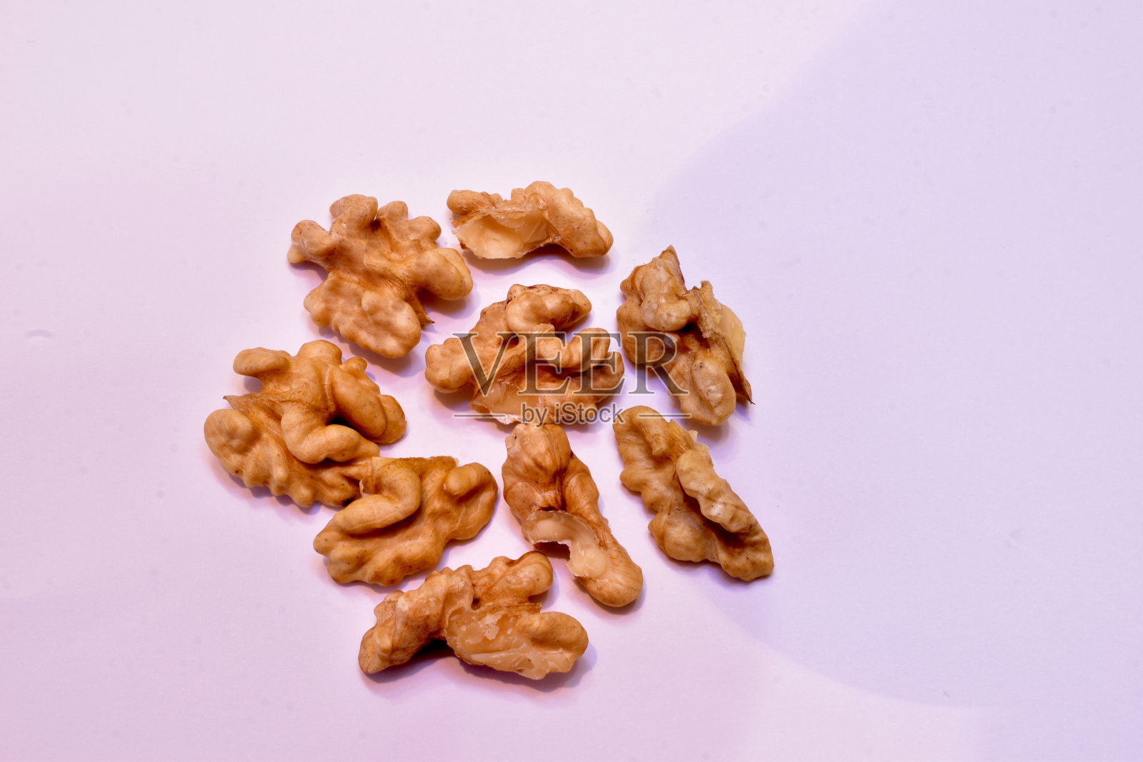 成熟的核桃仁，没有果皮，躺在白色的上面。照片摄影图片