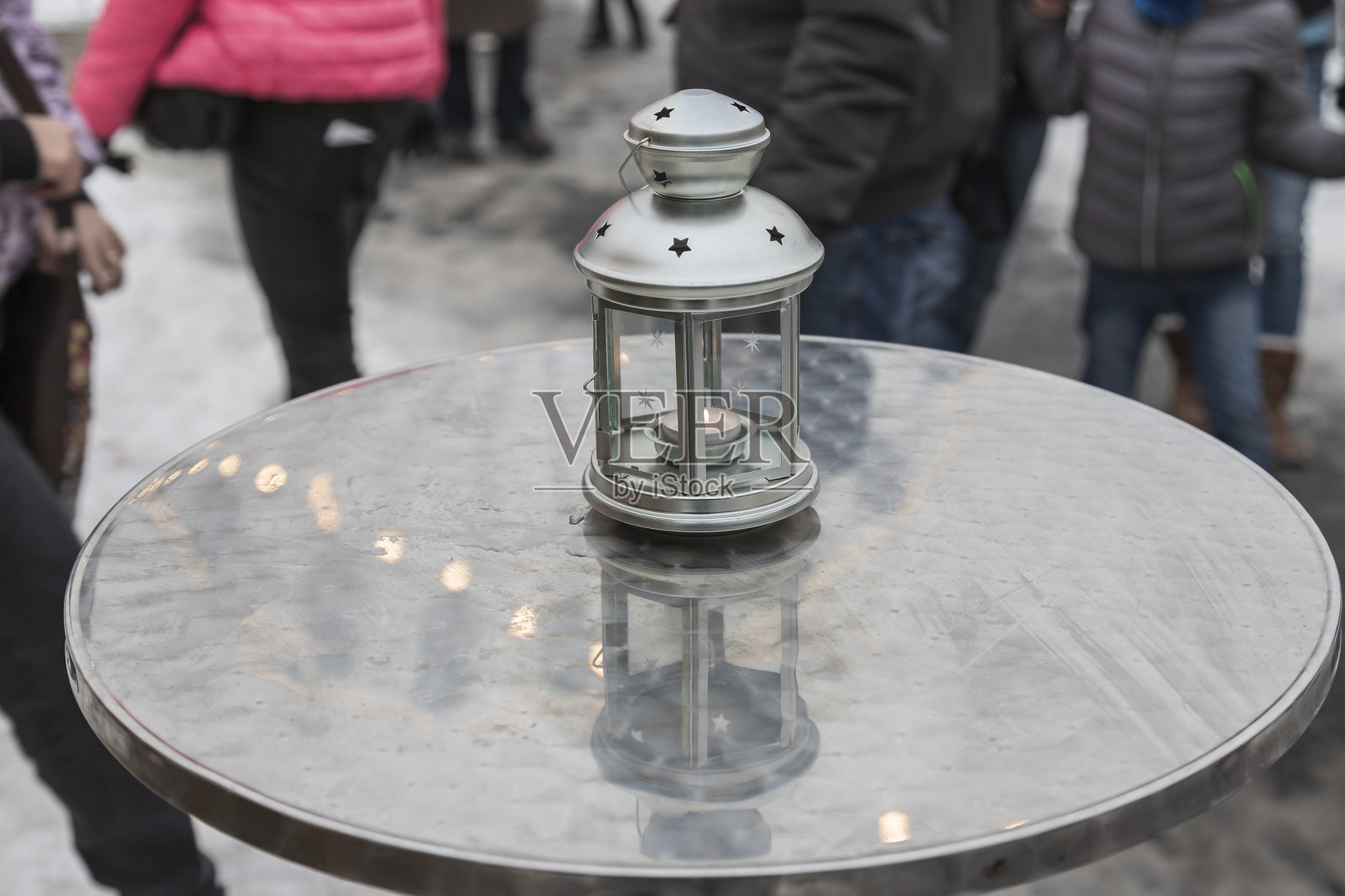 城市里的金属桌子上放着蜡烛。光从桌子上反射回来。照片摄影图片