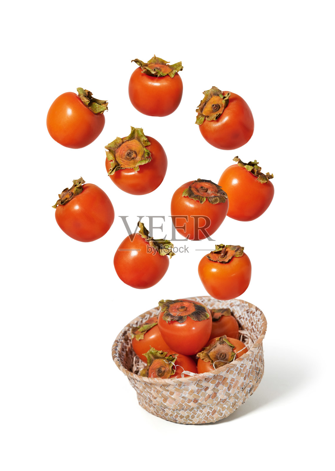 新鲜的柿子飞在一个柳条碗孤立的背景照片摄影图片