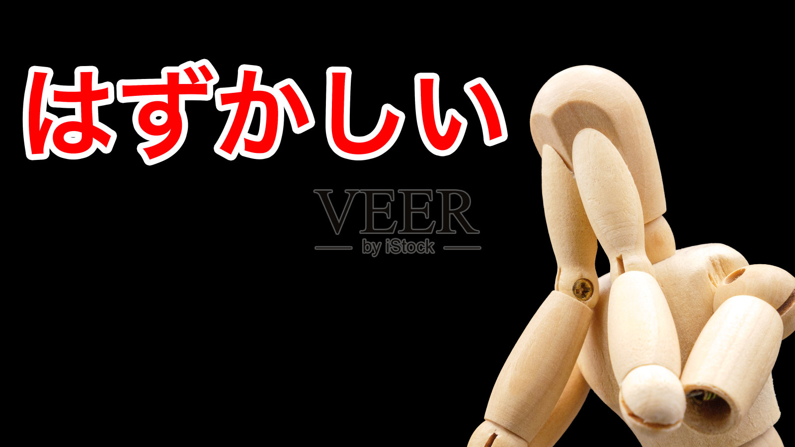 一个绘画娃娃，摆出“尴尬”的姿势隐藏自己的脸照片摄影图片