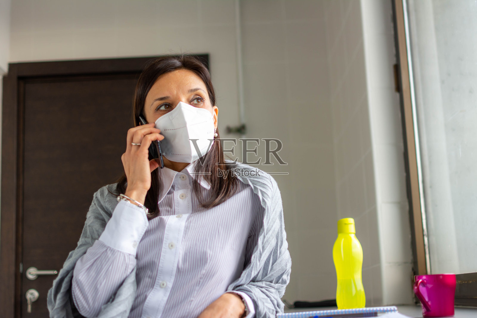 COVID-19大流行期间办公室的安全，商业人士戴口罩照片摄影图片