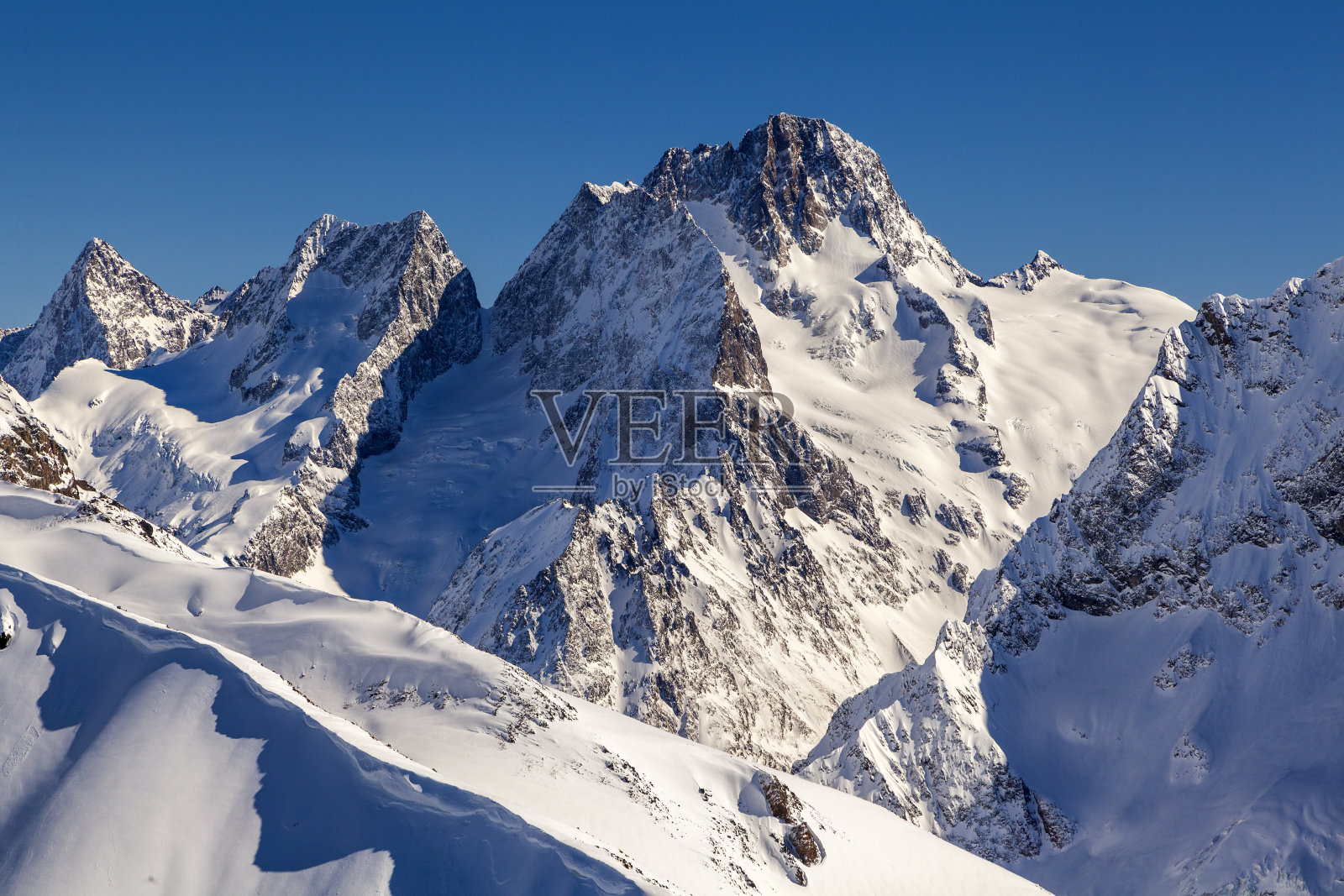高加索山脉，在冬天的白天，贝拉卡亚山、索弗鲁德朱山和苏拉哈特山的滑雪斜坡的全景。东拜滑雪胜地，西高加索，卡拉奇-切克斯，俄罗斯。照片摄影图片