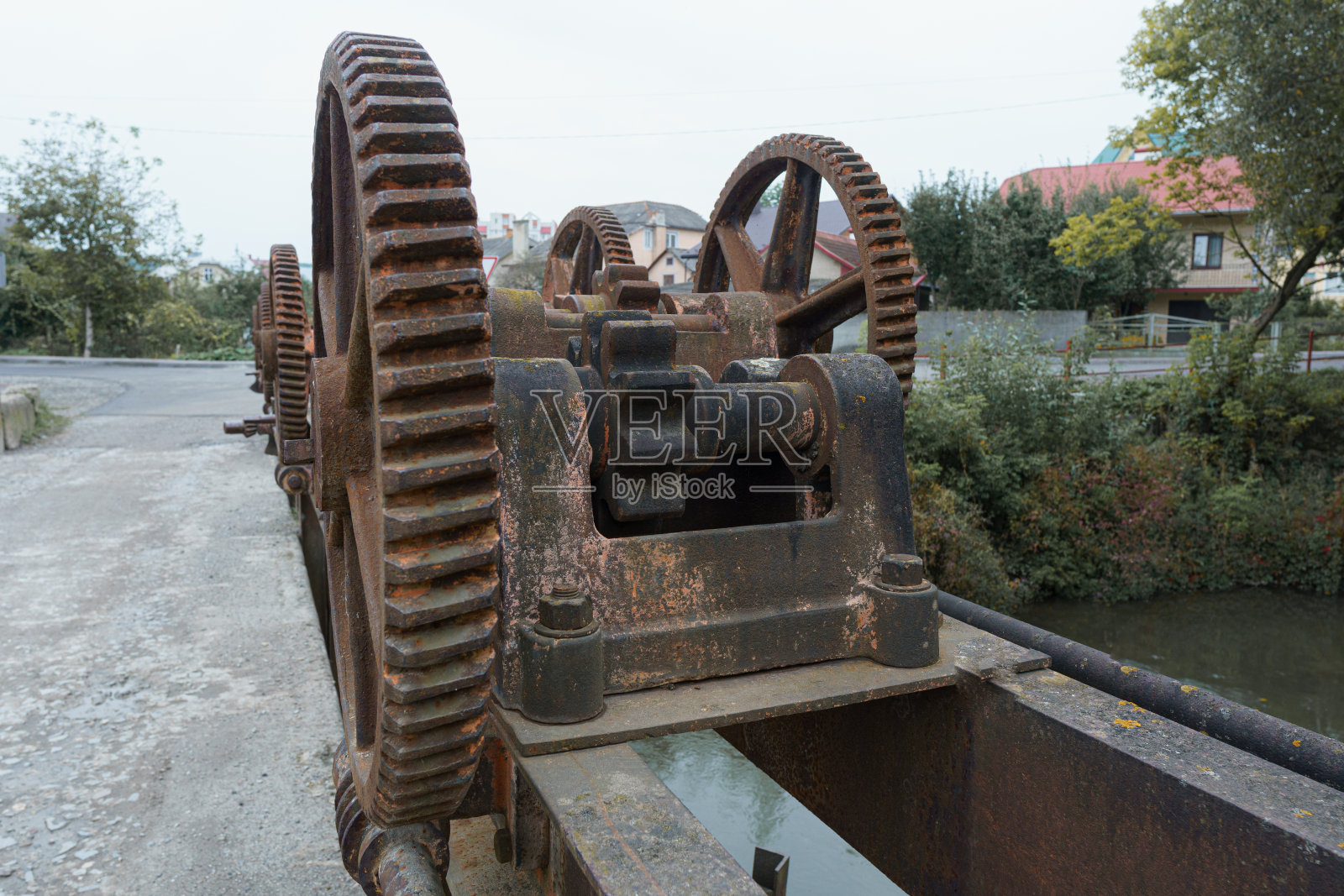 废弃的水坝上有旧的金属齿轮机械装置照片摄影图片