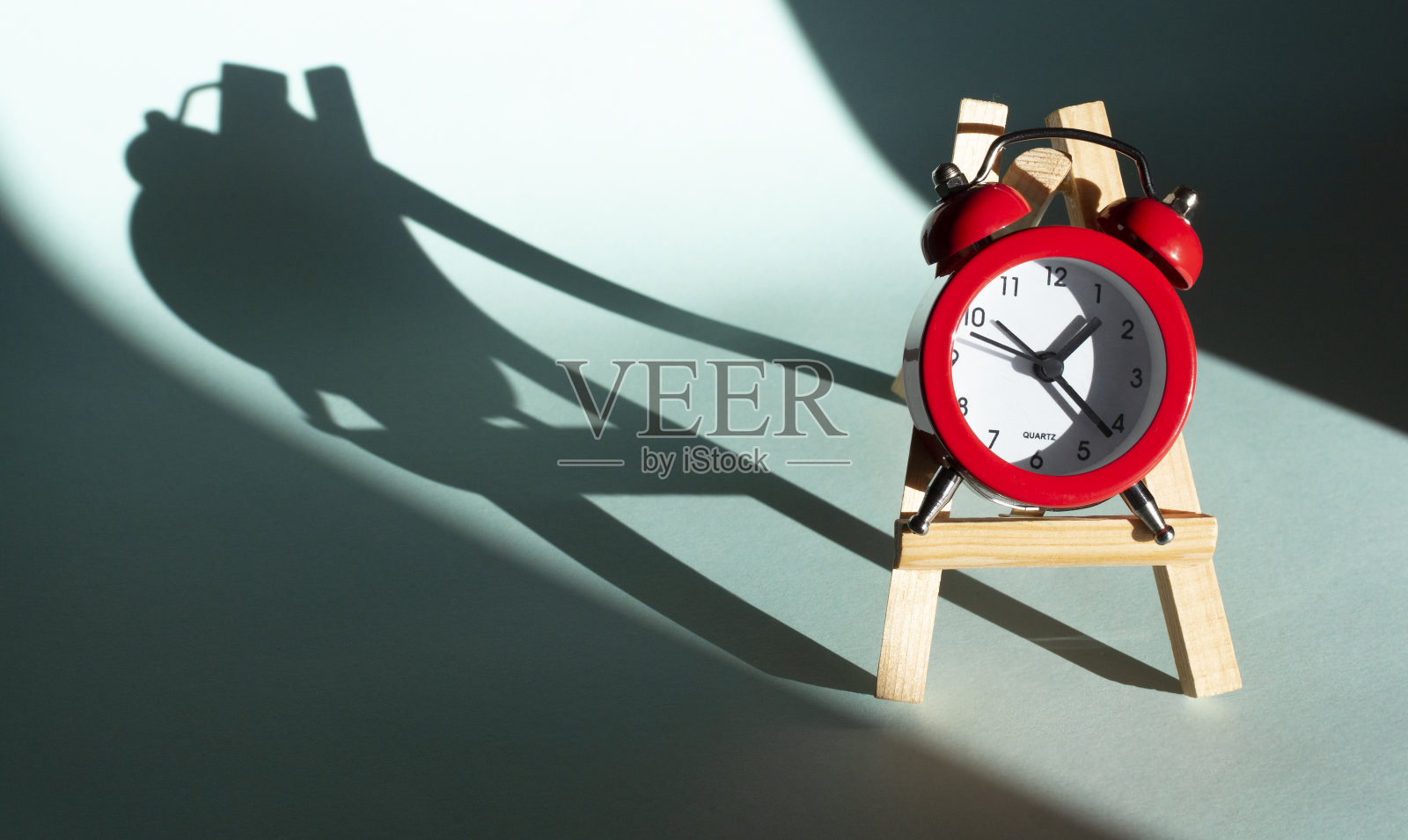 红色圆形模拟闹钟隔离在蓝色背景上照片摄影图片