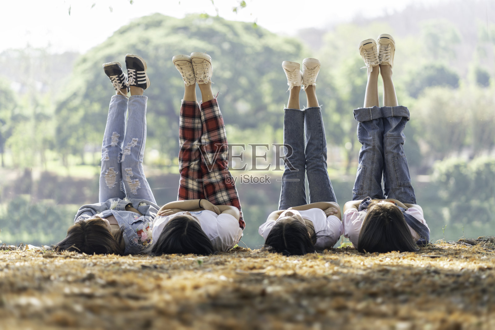孩子们喜欢在清爽的公园和有趣的假期里，把腿从干草上伸出来，享受大自然的舒缓气氛。照片摄影图片