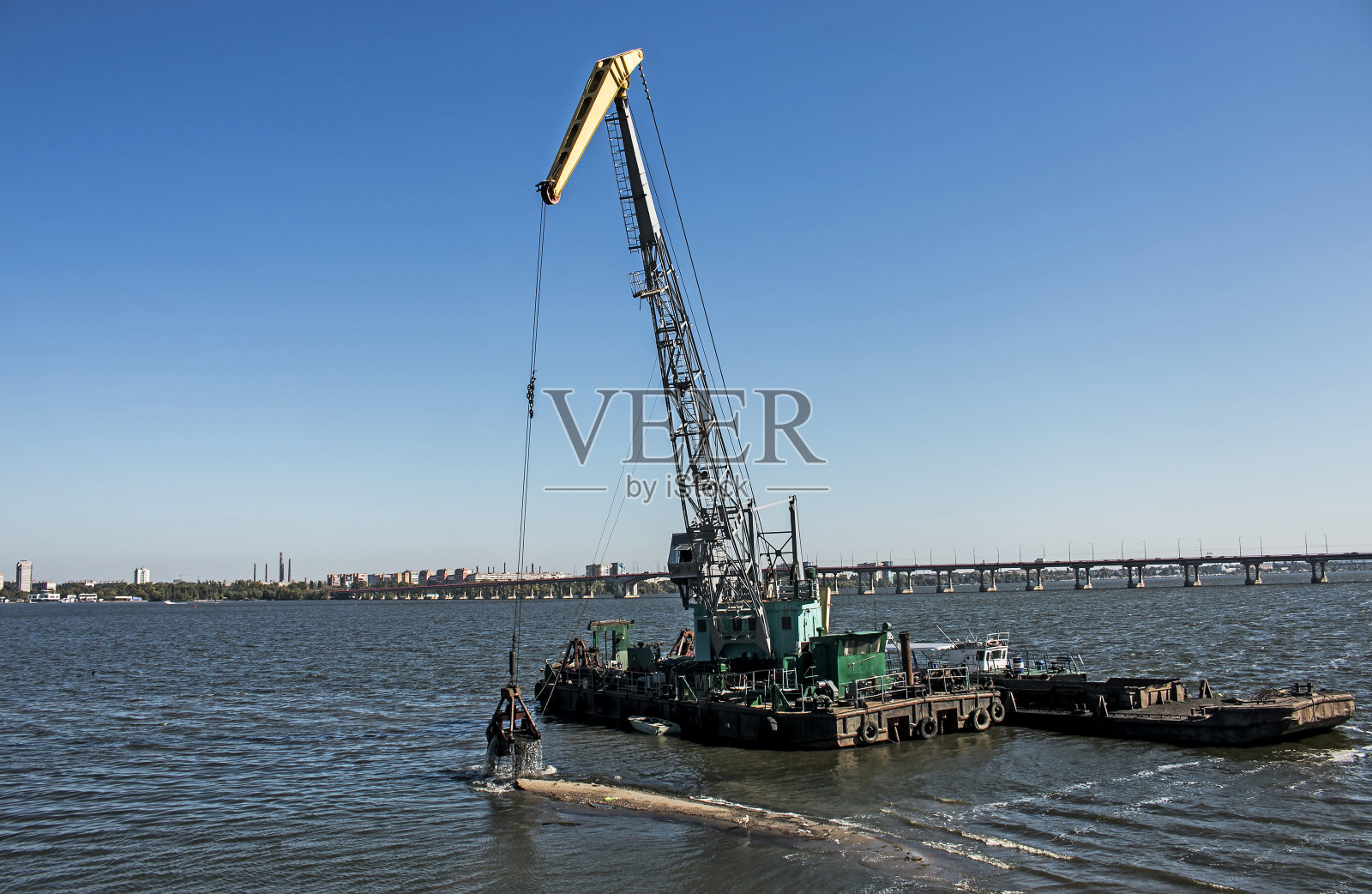 用挖泥船从第聂伯河上的工业废料中清理新形成的岛屿。照片摄影图片