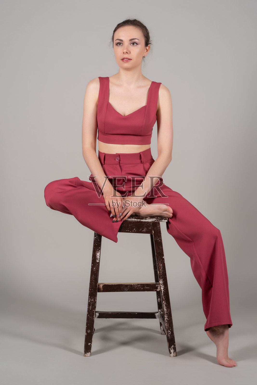 全身照片迷人别致的商务女士坐椅子穿红色西装孤立的灰色背景照片摄影图片