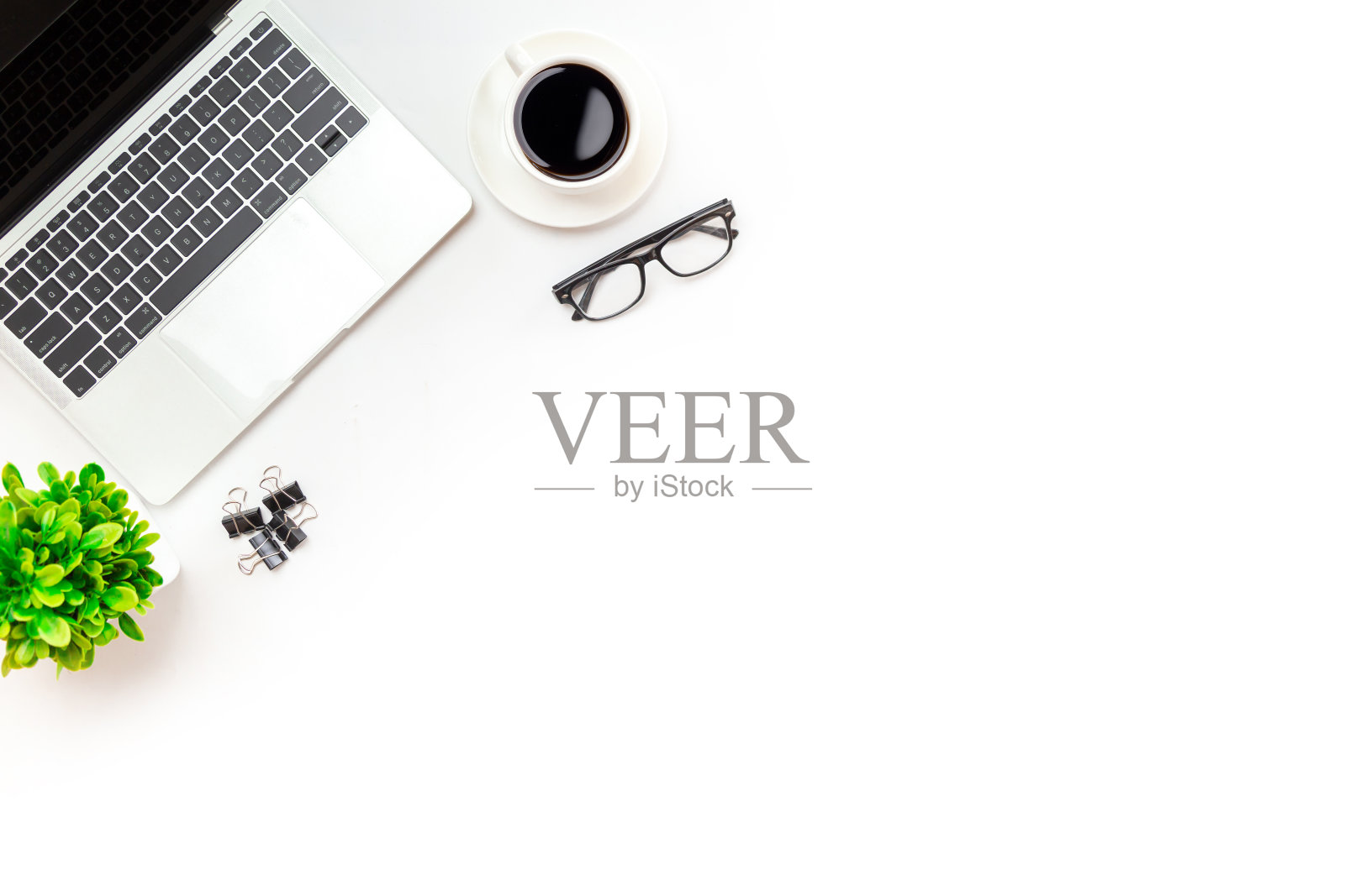 白色的办公桌桌上有空白的笔记本电脑、电脑键盘等办公用品。顶视图，复制空间，平铺。照片摄影图片