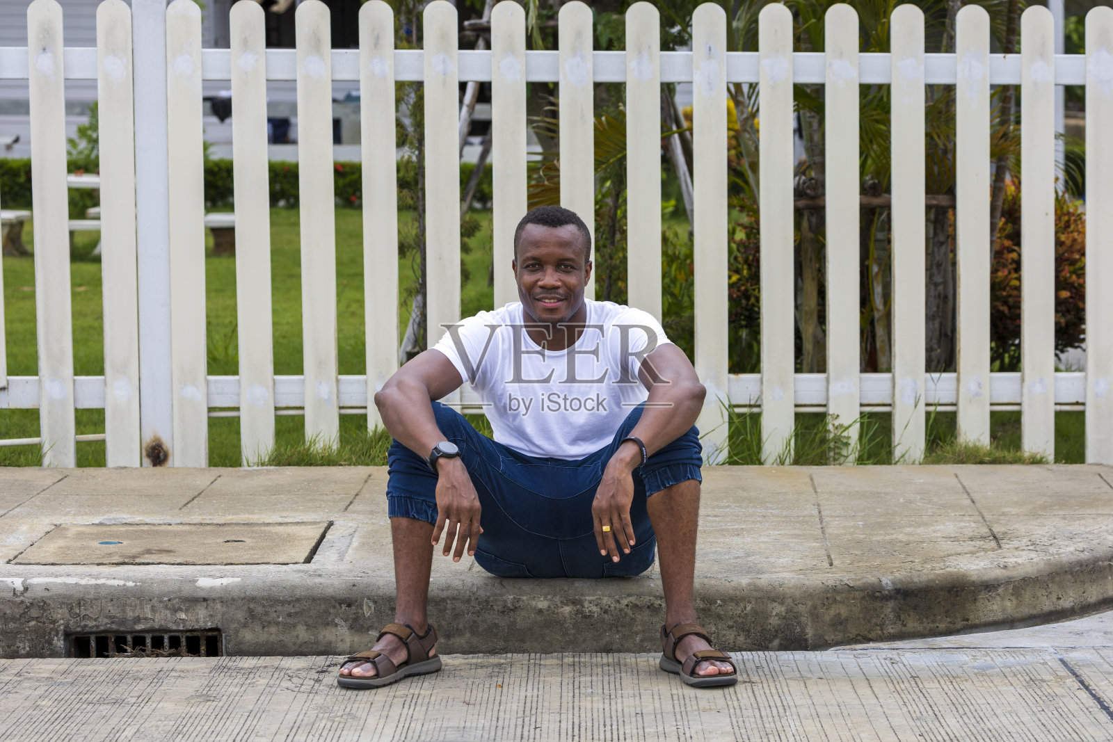 一个健康的非洲裔美国人坐在他的房子前放松，在和平的社区照片摄影图片