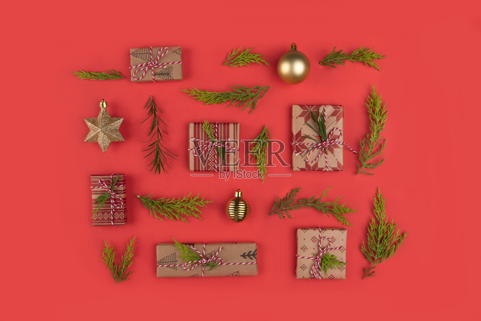在红色背景上的圣诞礼物，松枝和圣诞玩具的顶部视图。圣诞节平。照片摄影图片