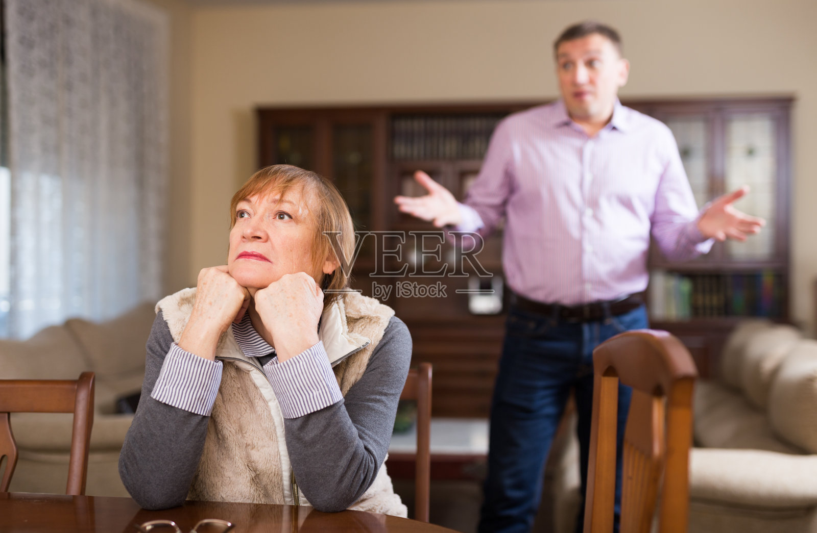 与成年儿子争吵后沮丧的老年妇女照片摄影图片