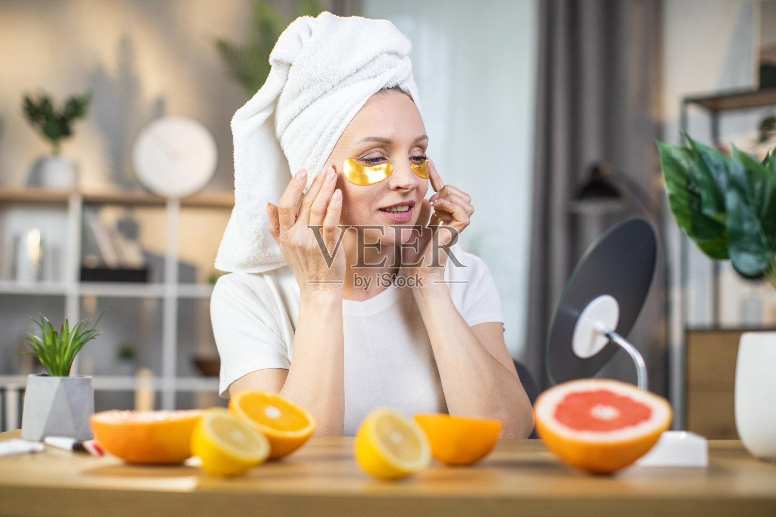 戴着水凝胶垫的女人在照镜子照片摄影图片