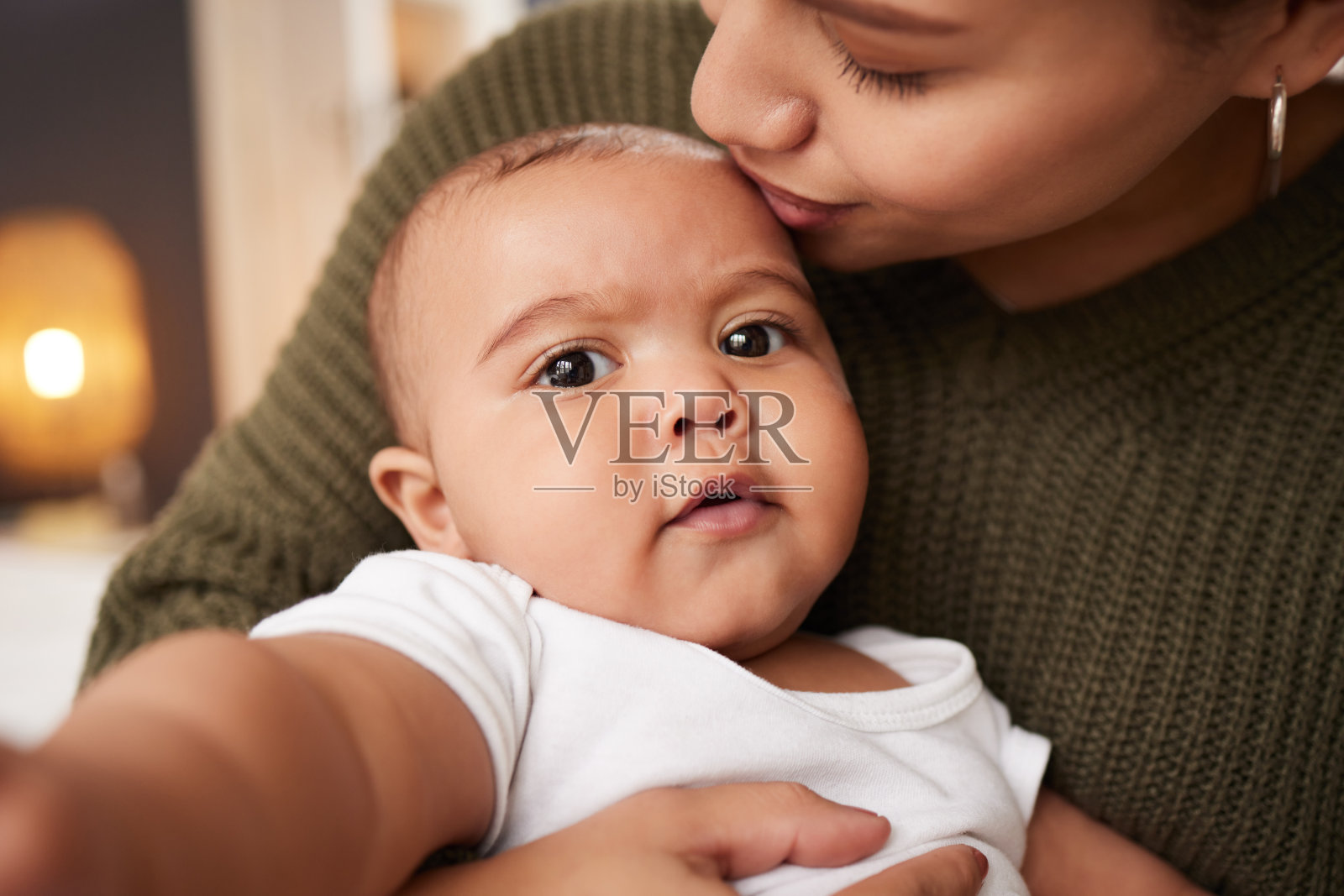一名年轻妇女在家中抱着孩子照片摄影图片
